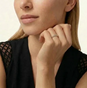 Slim 18K gold diamond studded ring worn on female model hand close-up view