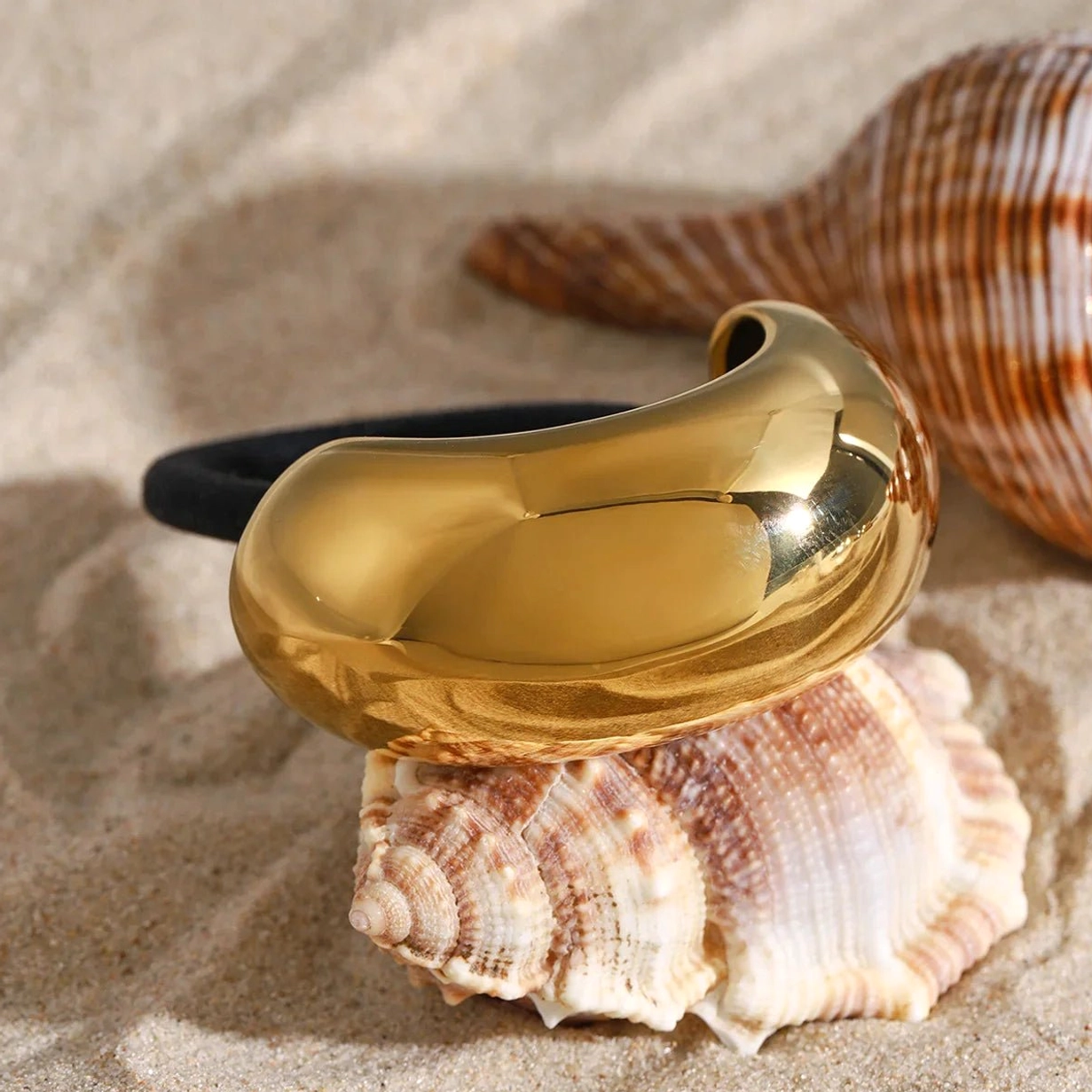 Luxury 18K gold ponytail cuff with conch shell beach props, polished metal finish
