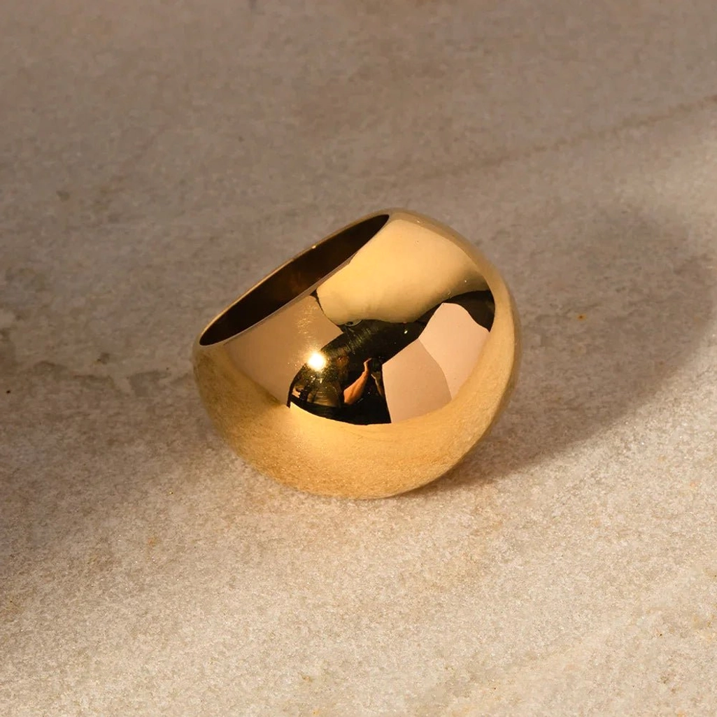 18K Gold Dome Ring Side View - Curved Dome Top Thick Reflective Band on Textured Countertop