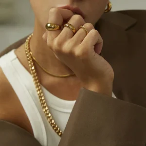18K gold stackable thin rings close-up worn on female model hand layered jewelry styling
