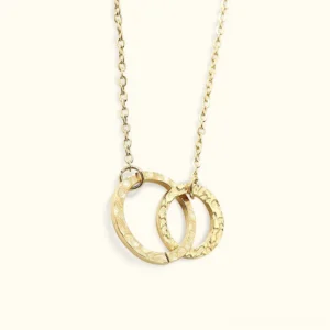 18K gold interlocking double hoop necklace with hammered texture finish flat lay on white background