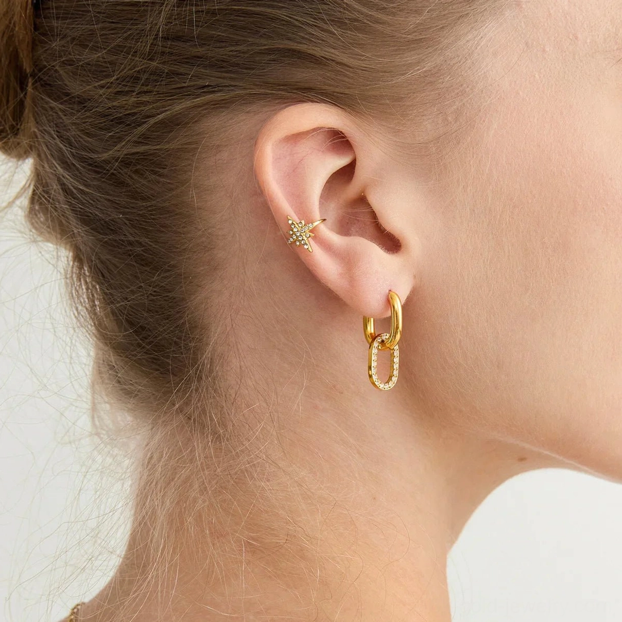 18K gold double hoop earrings paired with helix stud, mixed ear jewelry set close-up showing coordinated styling