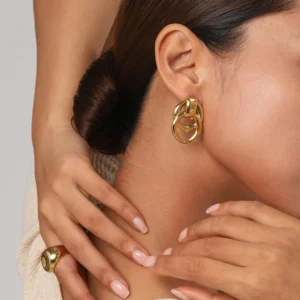 18K gold double link stud earrings close-up worn on ear side view model with bun hairstyle