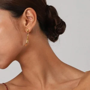 18K gold earrings worn on model's ear, side profile view showing elongated drop silhouette and fit on earlobe