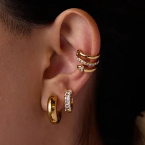 18K gold earring bundle three-piece set modeled on ear close-up side profile view with diamond huggies and chunky hoops