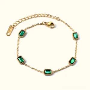 18K gold emerald station bracelet flat lay with diamond simulants adjustable chain