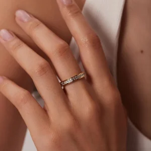 Woman's hand wearing 18K gold eternity ring, close-up detail shot showing sparkle and brilliance of diamond simulants