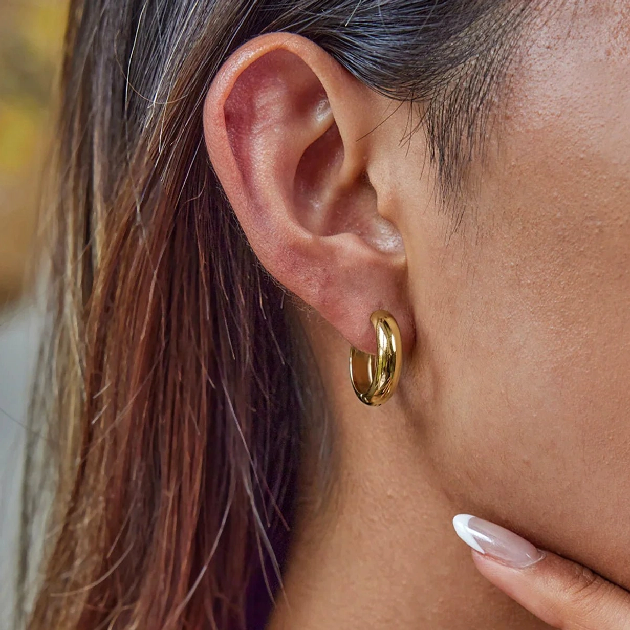 Everyday gold huggie hoop earrings slim profile on ear showing lightweight everyday design