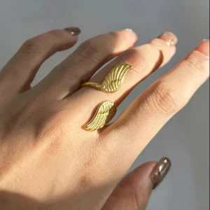18K gold feather wing adjustable ring worn on hand close-up side view female model showing detailed engraved feather texture and fit