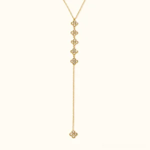 18k gold floral lariat drop necklace with clover charms flat lay front view beige background