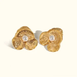 18K gold floral pearl stud earrings flat lay product photography on neutral background showing textured three-petal flower design with luminous pearl center