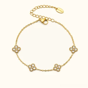 18K yellow gold four-leaf clover bracelet with diamond simulant gemstones, flat lay studio photography