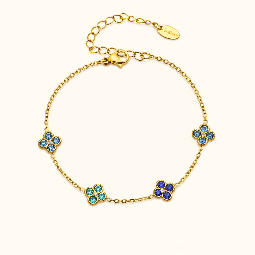 18K yellow gold four-leaf clover bracelet with blue sapphire gemstone charms, flat lay product view