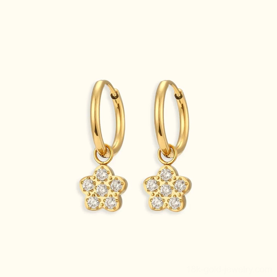 18K gold four-leaf clover huggie hoop earrings with cubic zirconia pavé charm flat lay