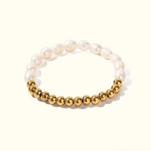 18K gold and white freshwater pearl stretch bracelet on plain background, featuring polished gold metal beads alternating with lustrous white pearls in elegant flat lay