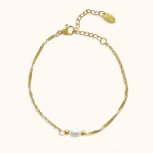 Twisted gold chain freshwater pearl bracelet flat lay top view with white oval pearl and gold accent beads adjustable extender