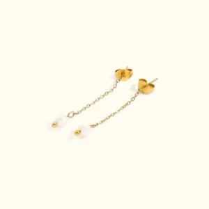18K gold-tone freshwater pearl drop earrings flat lay overhead view featuring delicate chain and heart-shaped stud backs on neutral background