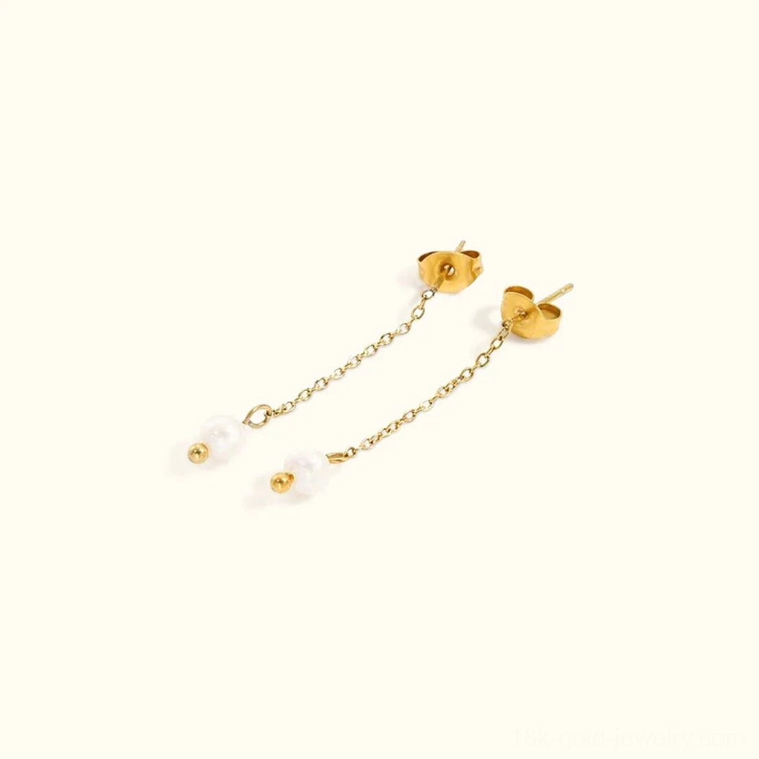 18K gold-tone freshwater pearl drop earrings flat lay overhead view featuring delicate chain and heart-shaped stud backs on neutral background