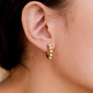 Pearl hoop earrings worn on model ear showing elegant pearl arrangement and gold finish