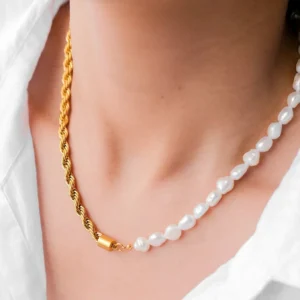 Dualia 18K gold pearl necklace worn close-up on woman's neck with white top, showcasing mixed chain and pearl design