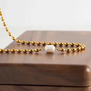 18K gold pearl necklace displayed in luxury wooden jewelry box with rich brown velvet lining - gift presentation view
