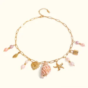18K gold freshwater pearl coastal charm necklace flat lay showing seashell and starfish ocean-themed charms on gold chain