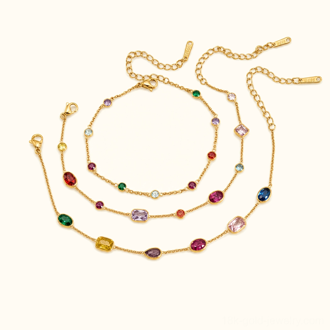 Collection of 18K gold gemstone jewelry including multicolor bezel-set bracelet with various gem cuts and adjustable clasps on clean background