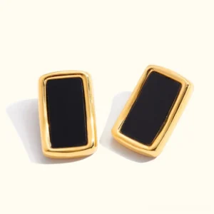 18K gold geometric enamel stud earrings flat lay product shot with curved rectangular gold frame and black enamel inlay on off-white background
