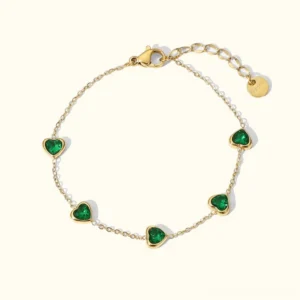 18K gold green heart charm bracelet flat lay top view on white background showing multiple bezel-set emerald heart stones with adjustable gold cable chain