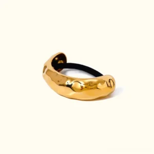 Single 18K gold hammered arch cuff flat lay with integrated black hair band