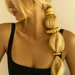 18K gold hammered arch hair cuff worn by woman blonde hair black camisole side close-up view polished gold texture