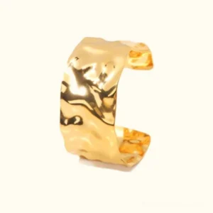 18K gold hammered open cuff bracelet top view flat lay with textured surface detail on white background