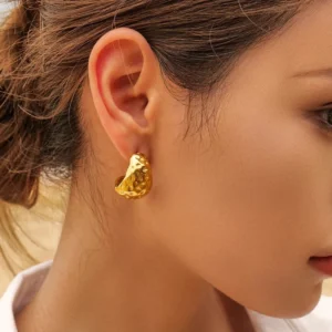 18K gold hammered hoop earrings worn on ear - close-up side view showing snug fit and polished gold finish
