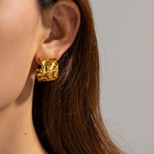 asymmetric gold hammered hoops worn on model side view close-up