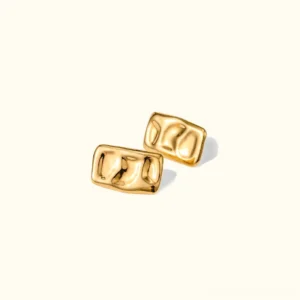 18K gold hammered rectangular stud earrings with polished wavy textured surface, studio flat lay on plain light background