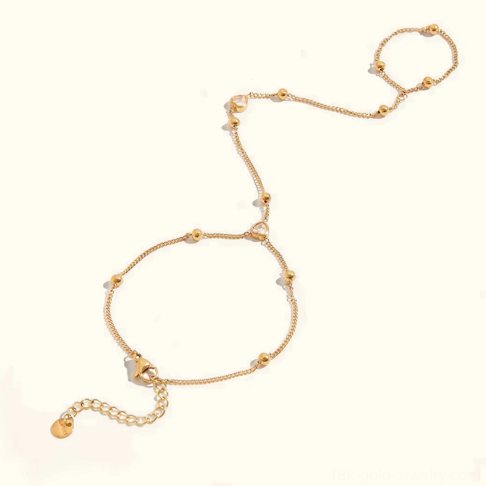 18K gold hand chain bracelet with heart cubic zirconia charm, adjustable finger chain flat lay on white background, detailed product view