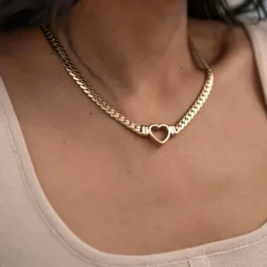 Woman wearing dual-tone 18K gold heart choker with mixed silver and gold curb chain displayed on neck with light pink top