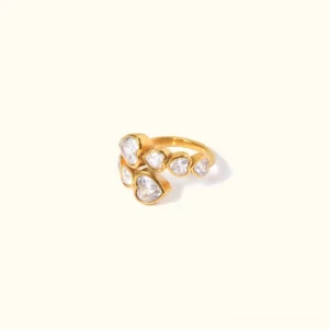 18K gold heart cluster ring adjustable overhead flat lay view with heart-shaped and round diamond simulants on light beige background