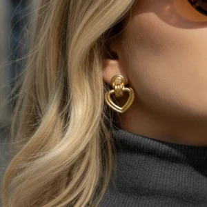 Close-up of 18K gold heart earrings worn on earlobe - side profile detail shot