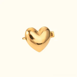 Single 18k gold heart hair clip flat lay, top-down view displaying smooth polished gold finish and metal clasp attachment mechanism