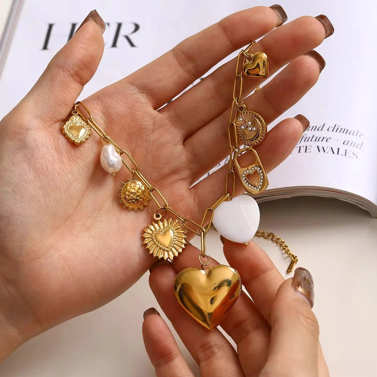 18K gold heart locket necklace in hands showing detachable heart locket pearl white charm accents, hands-on product view