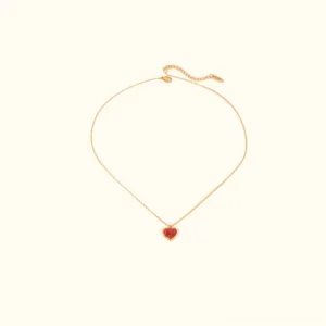 18K gold heart necklace with red gemstone pendant on plain background, flat lay view showing adjustable chain and polished bezel setting
