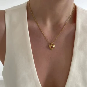 Dainty 18K gold heart necklace worn on model showing delicate pendant on collarbone with gold chain