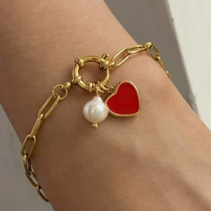 18K gold pearl heart charm bracelet worn on wrist - close-up wearable view showing elegant design