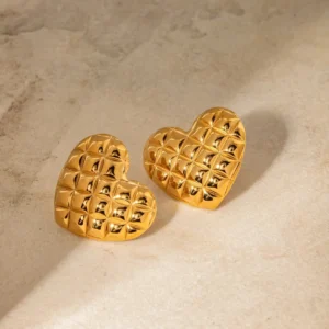 Luxurious 18K PVD gold heart earrings featuring embossed grid pattern, three-dimensional puffy design on marble surface