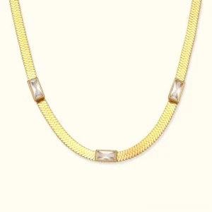 18K gold herringbone necklace with baguette crystals flat lay front view