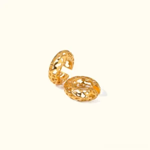 18K gold hollow hoop earrings flat lay top-down view showcasing intricate carved lattice-work design and polished gold finish