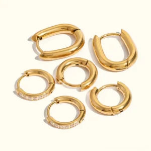 Three 18K gold hoop earring styles flat lay on white background, u-shaped hoops round huggie hoops and cubic zirconia diamond hoops