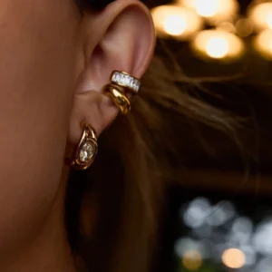 18K gold hoop earring worn on model ear showing polished finish and sparkle in warm natural light