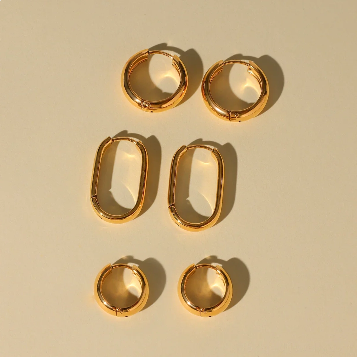 Complete 18K gold hoop earrings collection three pairs top-down view showing all styles together
